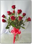Always appropriate, the timeless elegance and classic beauty of red roses. 12 Red Roses arrive with greens in a glass vase and trimmed with a red ribbon bow.