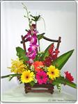 Send your friend birthday wishes that will last well past their special day with this basket arrangement of orchids, mixed gerbera daisies and greens.